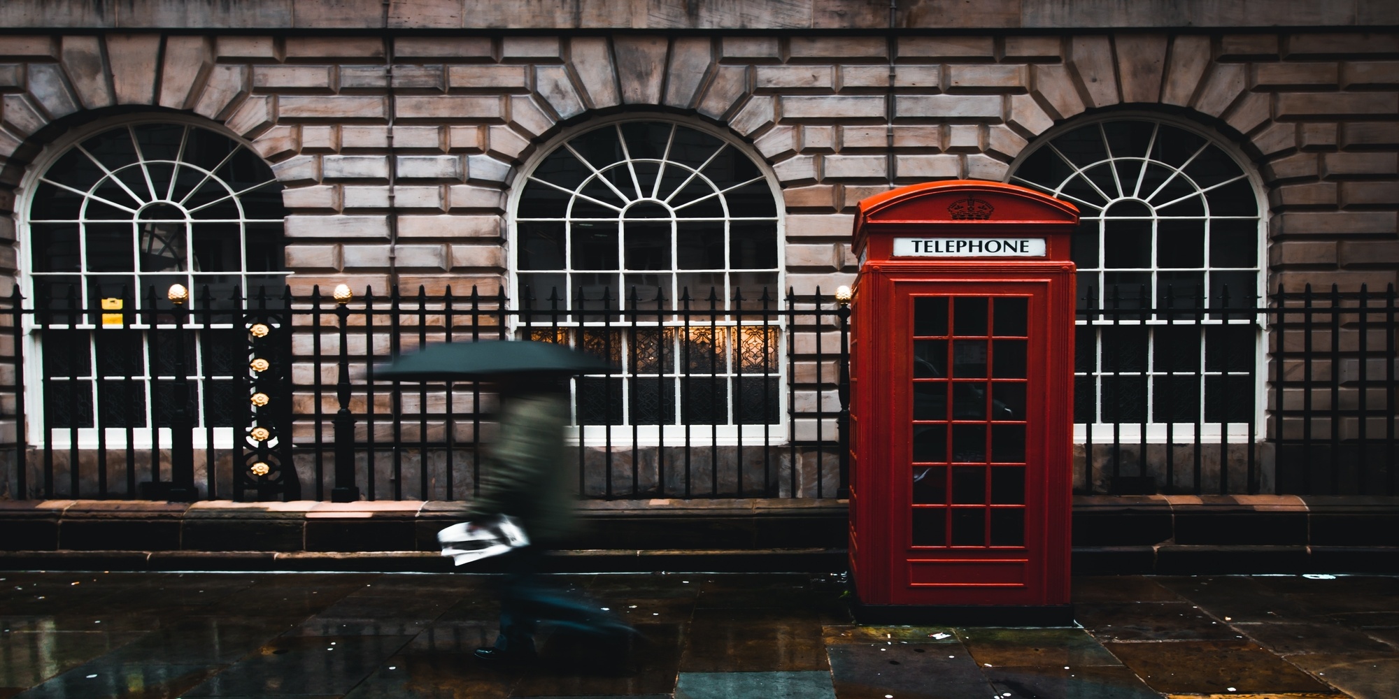 street in london with phone box and person walking