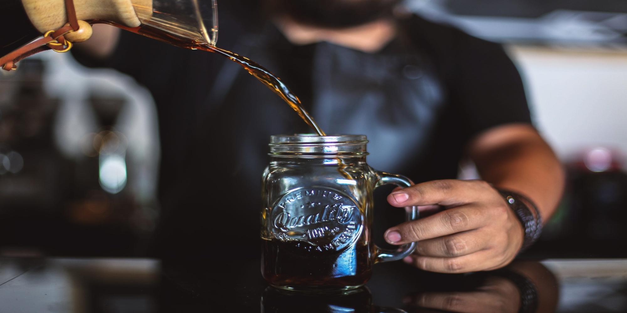 Man pouring specialty cold brew coffee into jar