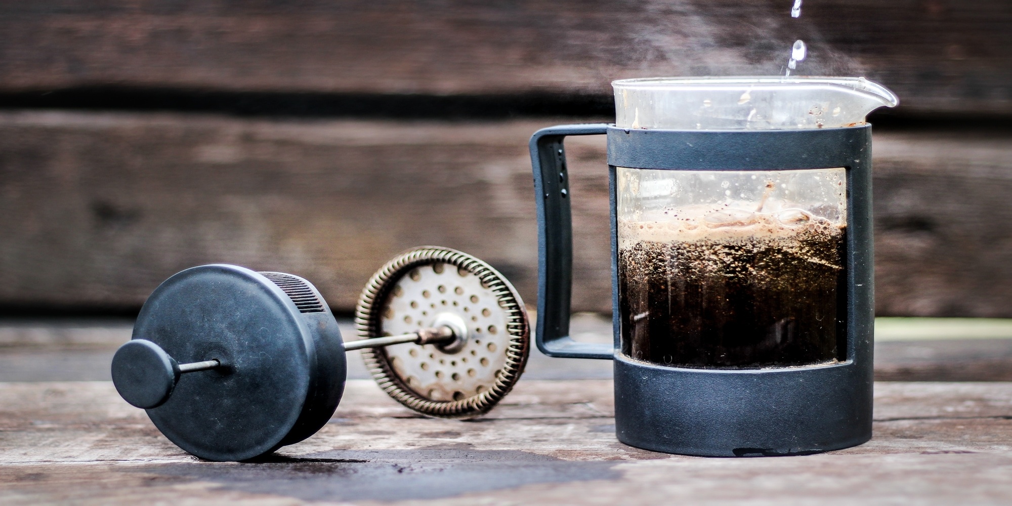 french press pouring water into coffee