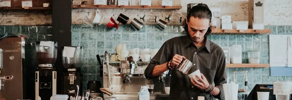 man brewing coffee in coffee shop