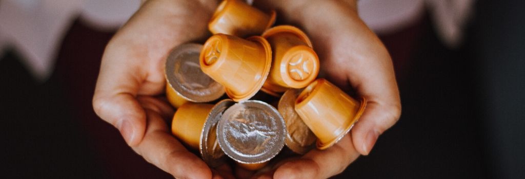 person holding coffee pods in hands