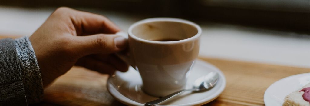 person holding ristretto cup about to consume drink