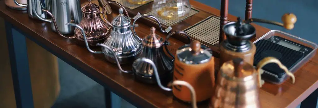 variety of different gooseneck kettles lined up on table