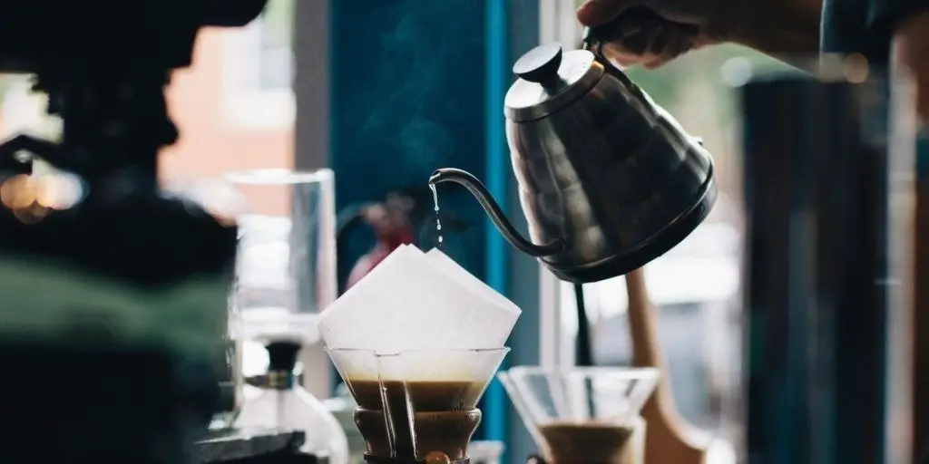 Person pouring water into Chemex from gooseneck kettle