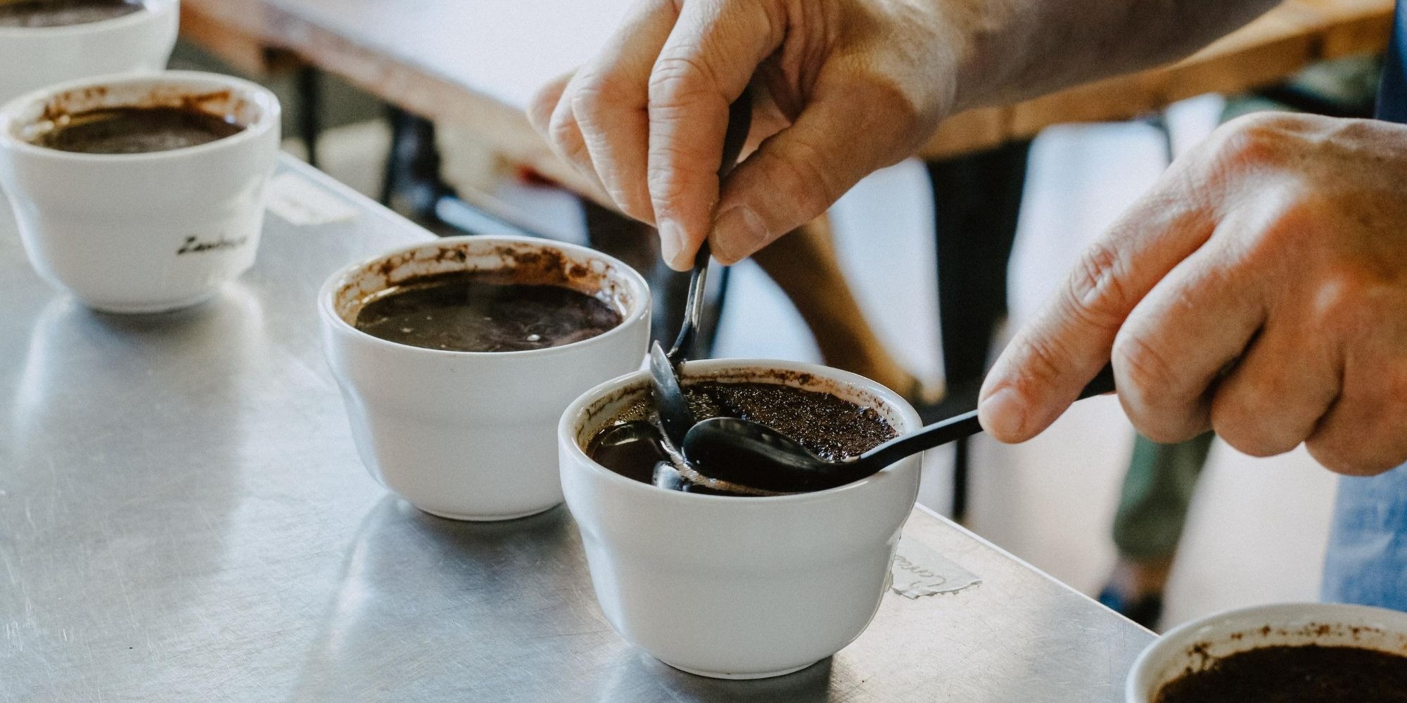 person tasting coffee in cupping session