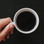person holding black coffee in white cup