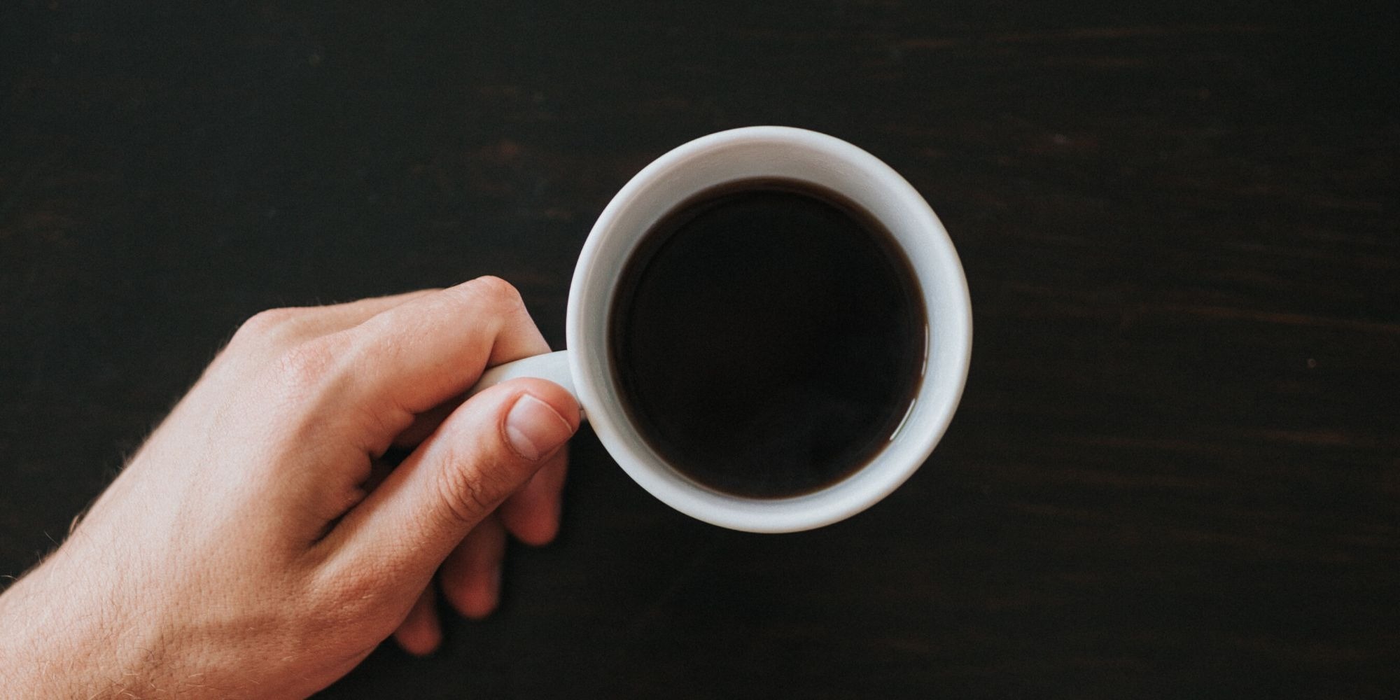 person holding black coffee in white cup