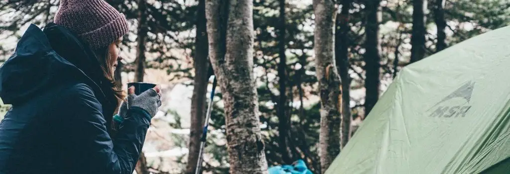 woman holding coffee while camping