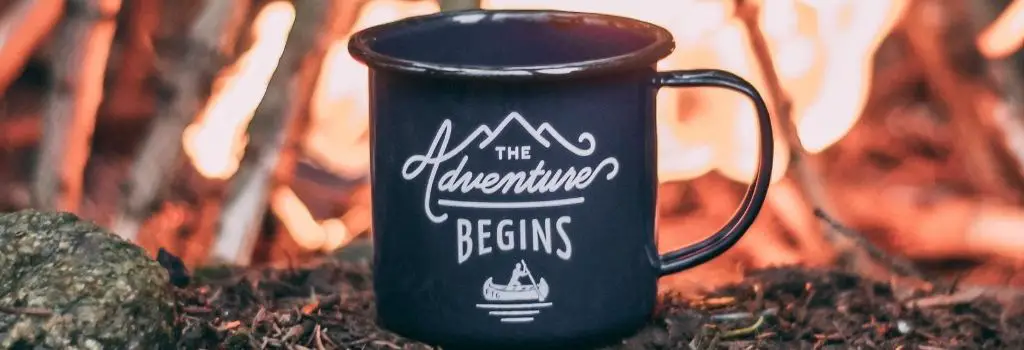 coffee mug in front of fire camping